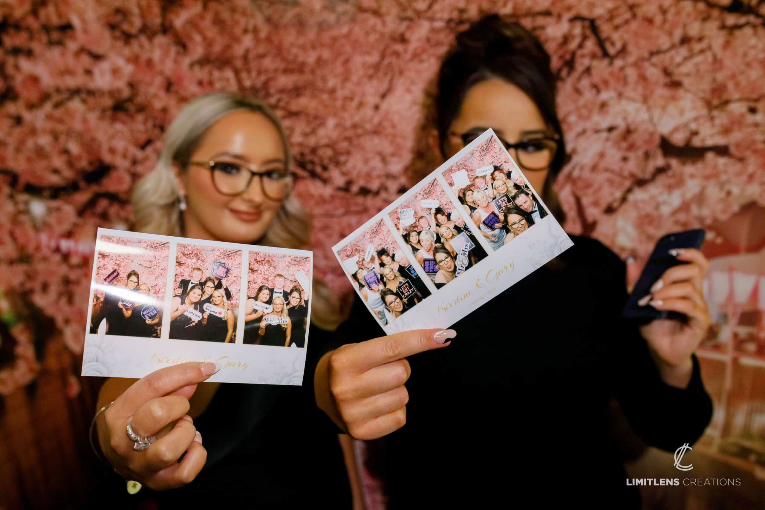 Ladies holding photo prints they had taken at a wedding